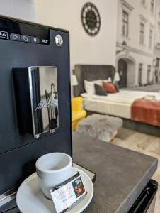 a cup of coffee on a plate on a table in a room at ZamStudio Kraków Zamenhofa 4 in Krakow