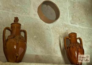 dos jarrones marrones sentados en una mesa con un espejo en A casa di Tullio en Fasano