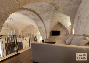 una sala de estar con sofá en una habitación con techo en A casa di Tullio en Fasano
