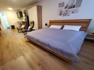Schlafzimmer mit einem großen Bett mit einem Kopfteil aus Holz in der Unterkunft Ferienwohnung Blumenstiel in Maikammer