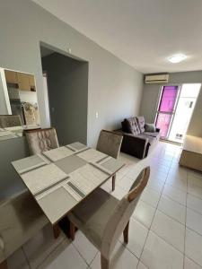una sala da pranzo con tavolo, sedie e divano di Belo Apartamento em Condomínio ad Ananindeua