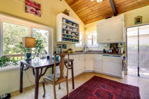 a kitchen with a desk and a table and some windows at Lakefront Glen Ellen Cabin with Views Near Wineries! in Glen Ellen