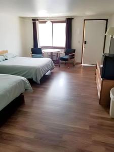 ein Hotelzimmer mit 2 Betten und einem Tisch in der Unterkunft Unit #22 at Snooze in Wisconsin Rapids