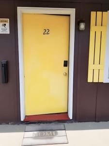 eine gelbe Tür mit der Nummer drauf. in der Unterkunft Unit #22 at Snooze in Wisconsin Rapids