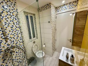La salle de bains est pourvue de toilettes et d'une douche en verre. dans l'établissement Heart of the Paceville Modern Apartment!, à San Ġiljan