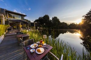 a table with food on it next to a body of water at Hotel Mitland in Utrecht