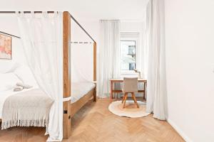 a bedroom with a canopy bed and a desk at Cozy Apartment in Quiet Location, Fast Train Station 100m Away, contactless check-in in Vienna
