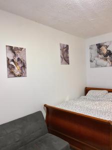 a bedroom with a bed and three pictures on the wall at Chambre charmante entre Paris et Disney in Noisy-le-Grand