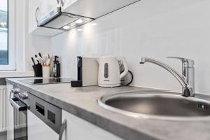 eine Küchentheke mit Spüle und Toaster darauf in der Unterkunft Cozy Apartment in Quiet Location, Fast Train Station 100m Away, contactless check-in in Wien