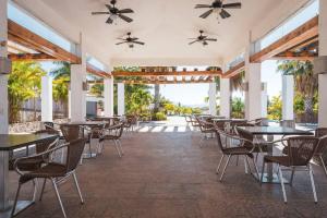 a restaurant with tables and chairs and a patio at Villa Exclusiva en Cuernavaca: Casa con Alberca in Xochitepec