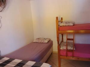 a room with two beds and a bunk bed at Pousada do Osvaldo Imbé in Imbé