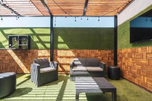 a patio with two chairs and a flat screen tv at Villa Exclusiva en Cuernavaca: Casa con Alberca in Xochitepec