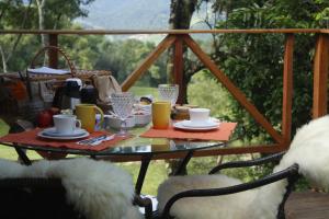 a table with food and drinks on a porch at Cabana Gracillis em Alfredo Wagner - Serra Catarinense in Alfredo Wagner
