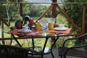 阿弗雷多瓦格內的住宿－Cabana Gracillis，露台上的玻璃桌,配有食物和饮料