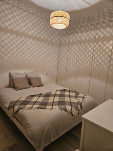 a bedroom with a bed with a plaid blanket at appartement 93 proche stade de France in Saint-Denis