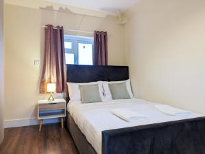 a bedroom with a bed and a lamp on a table at Rooms Near City Centre Private Bath Free Parking in York
