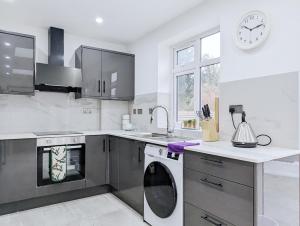 cocina con lavadora y reloj en la pared en Rooms Near City Centre Private Bath Free Parking en York