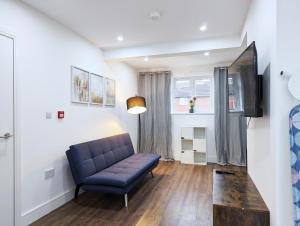 a living room with a blue couch and a tv at Rooms Near City Centre Private Bath Free Parking in York