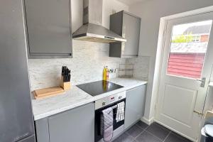 a kitchen with a sink and a counter top at Huge House - Free Parking - Quiet Location in Liverpool