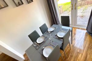 a dining room table with chairs and a table and a window at Huge House - Free Parking - Quiet Location in Liverpool