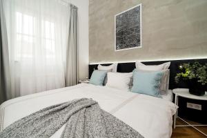 a bedroom with a large white bed with blue pillows at Luxurious two-bedroom in the Old Town in Prague