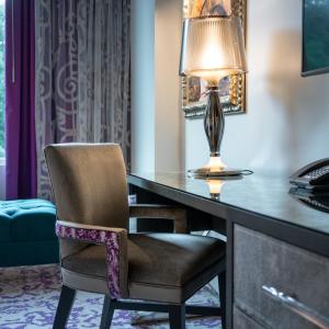 a desk with a lamp and a chair at Grand Bohemian Hotel Charlotte, Autograph Collection in Charlotte