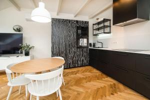 a kitchen with a wooden table and white chairs at Luxurious two-bedroom in the Old Town in Prague