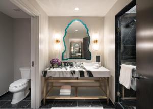 Grand Bohemian Hotel Charlotte, Autograph Collection في تشارلوت: حمام مع حوض ومرآة