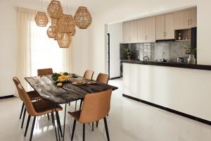 - une cuisine et une salle à manger avec une table et des chaises dans l'établissement Cove Fehendhoo, à Fehendhoo