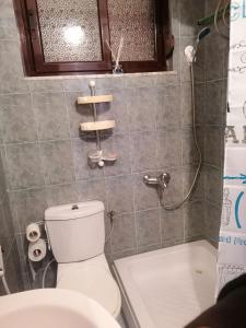 La salle de bains est pourvue d'une douche et de toilettes blanches. dans l'établissement Уютная квартира на берегу Адриатического моря, à Durrës