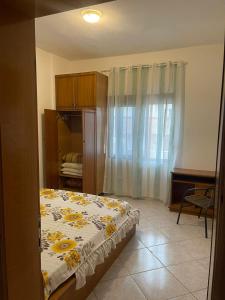 - une chambre avec un lit orné de fleurs jaunes dans l'établissement Уютная квартира на берегу Адриатического моря, à Durrës