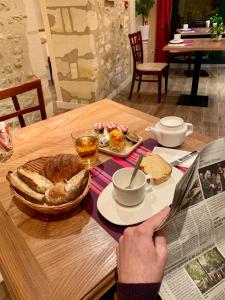 a table with a plate of bread and a newspaper at AUBERGE DU PORCHE in Blaye