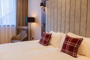 um quarto com uma cama com duas almofadas em Tynecastle Park Hotel em Edimburgo