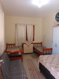 a bedroom with two beds and a window at Pousada do Osvaldo Imbé in Imbé