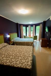 um quarto de hotel com duas camas num quarto em HOTEL TROPICAL IGUAZU em Puerto Iguazú