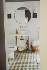 een badkamer met een wastafel, een toilet en een spiegel bij Casa Del Val- Villa Maria in San Bernardino