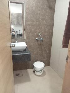 a bathroom with a toilet and a sink and a mirror at Namoh hotels in Ghaziabad