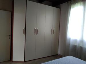 - une chambre avec des placards blancs et un lit dans l'établissement La Dèpendance, à Rimini
