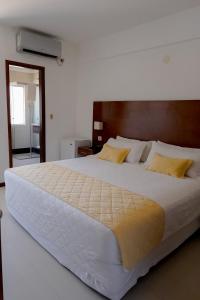 a bedroom with a large white bed with yellow pillows at Prince Hotel in Santa Cruz de la Sierra