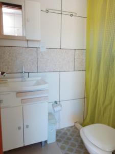 a bathroom with a toilet and a sink and a shower at Pousada do Osvaldo Imbé in Imbé