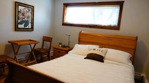 a bedroom with a bed with a pillow with the word home on it at Caruso's Accommodation in Jasper