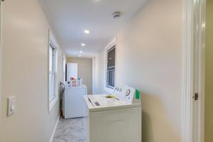 a white laundry room with a sink and a washer at Central Newark Apartment 1 Mi to Downtown! in Newark