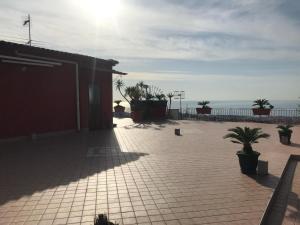 a building with a patio with plants and the ocean at La casetta di Ester in Ercolano