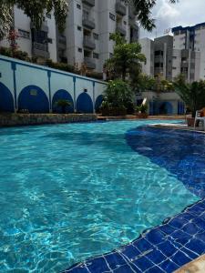 カルダス・ノバスにあるApartamento Caldas Novas Thermasの建物の前の青い水のプール +9枚の写真