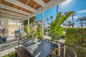 um alpendre com uma mesa de madeira e plantas em 2 Bedroom Oceanfront with Patio on the Boardwalk em Newport Beach