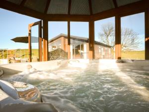 a jacuzzi tub in a building with windows at 2 Bed in Lochwinnoch 55854 in Kilmacolm