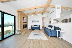 sala de estar con sofá azul y mesa en Immaculate Home with 180 degree views of the Beach & Ocean, en Newport Beach