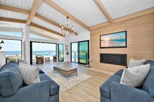 sala de estar con 2 sofás azules y TV en Immaculate Home with 180 degree views of the Beach & Ocean, en Newport Beach
