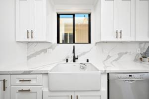 cocina blanca con fregadero y ventana en Immaculate Home with 180 degree views of the Beach & Ocean, en Newport Beach