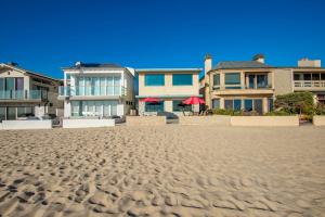 um grupo de casas na praia com piso arenoso em Upstairs 2 Bedroom Home with Ocean Views on 65th St em Newport Beach